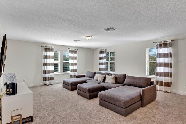 living room with light carpet, baseboards, visible vents, and a wealth of natural light