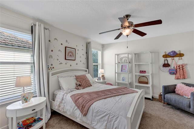 bedroom featuring baseboards, a ceiling fan, a textured ceiling, and light colored carpet