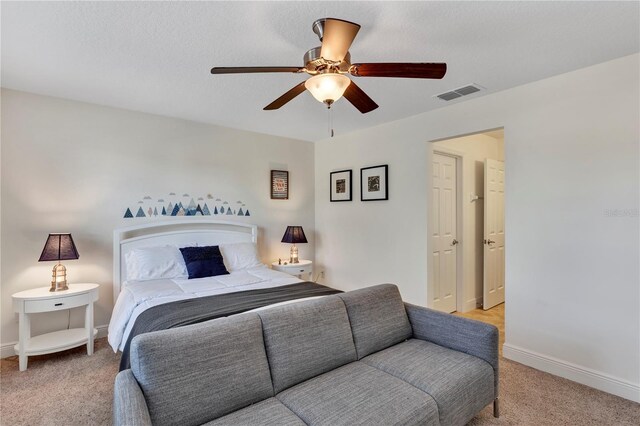 carpeted bedroom featuring a textured ceiling and ceiling fan