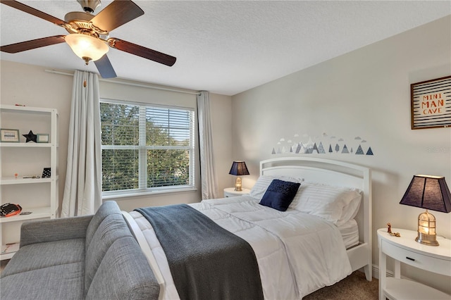 carpeted bedroom featuring ceiling fan and a textured ceiling