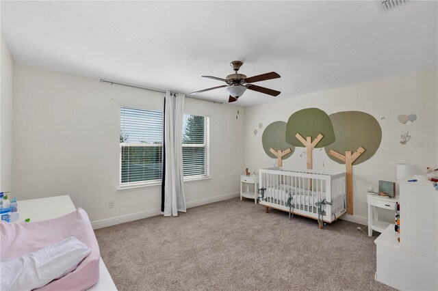 bedroom featuring baseboards, a ceiling fan, visible vents, and light colored carpet