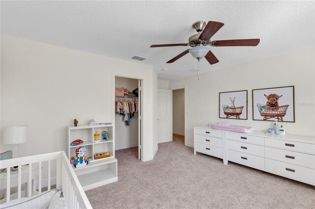 bedroom with light carpet, a closet, a textured ceiling, and visible vents