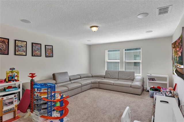 living area with a textured ceiling, carpet, and visible vents