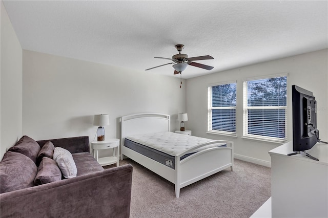 bedroom with ceiling fan, a textured ceiling, and carpet flooring