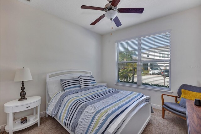 bedroom with light carpet, baseboards, and a ceiling fan