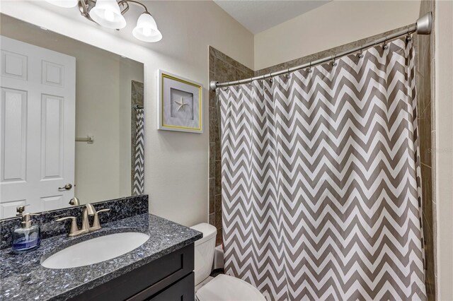 bathroom with toilet, vanity, and walk in shower