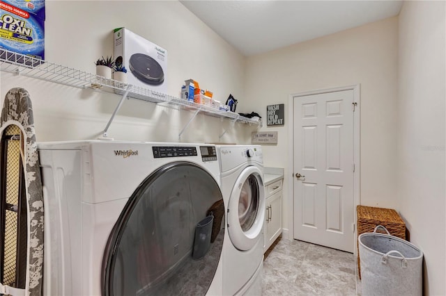 washroom with cabinets and washing machine and dryer