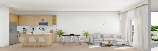 kitchen featuring light brown cabinets, light hardwood / wood-style flooring, a wealth of natural light, and stainless steel appliances