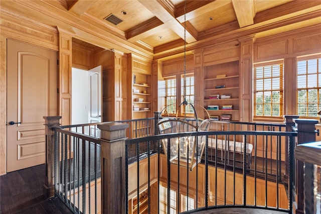 hallway featuring coffered ceiling, wooden ceiling, beamed ceiling, ornamental molding, and built in shelves
