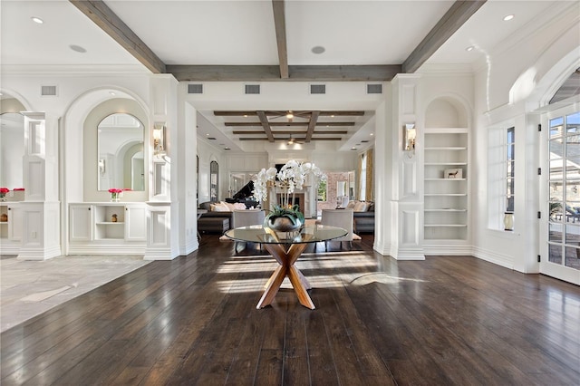 entrance foyer with a wealth of natural light, beam ceiling, wood-type flooring, and ornate columns