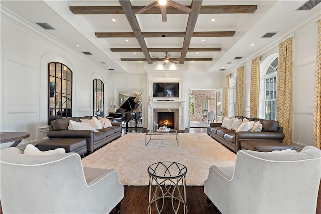 living room with ceiling fan, dark hardwood / wood-style flooring, coffered ceiling, and beamed ceiling