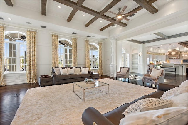 living room featuring beamed ceiling, ceiling fan, coffered ceiling, crown molding, and dark wood-type flooring