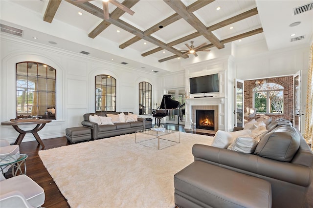 living room featuring coffered ceiling, ceiling fan with notable chandelier, beamed ceiling, and dark hardwood / wood-style floors
