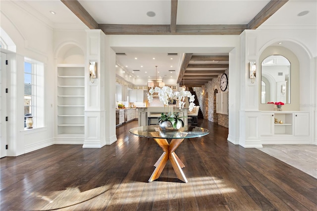 foyer featuring hardwood / wood-style floors, beamed ceiling, and decorative columns