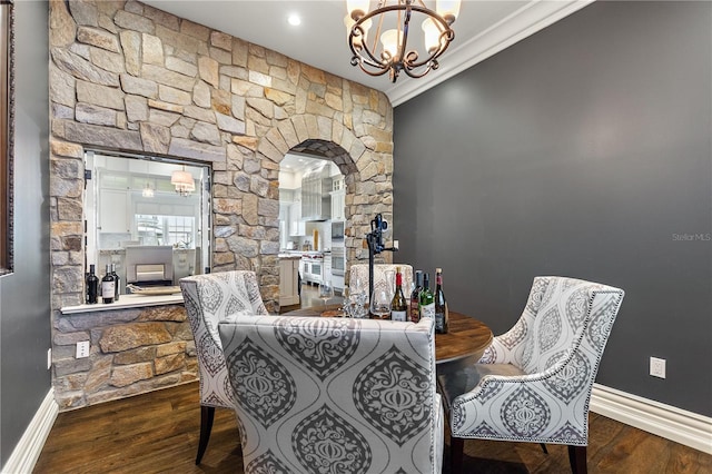 dining area with a notable chandelier, crown molding, and dark wood-type flooring