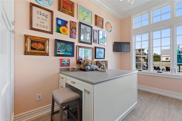 home office featuring light wood-type flooring and crown molding