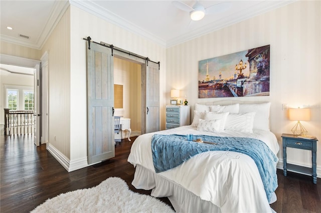 bedroom with ornamental molding, ceiling fan, a barn door, and dark hardwood / wood-style floors