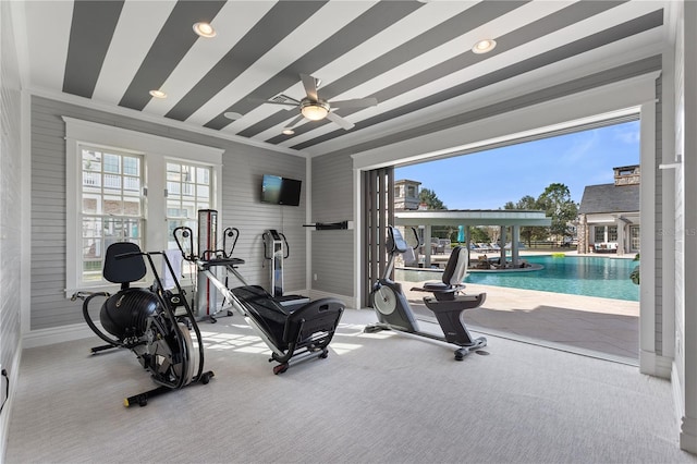 workout room with a swimming pool, carpet floors, ceiling fan, and ornamental molding