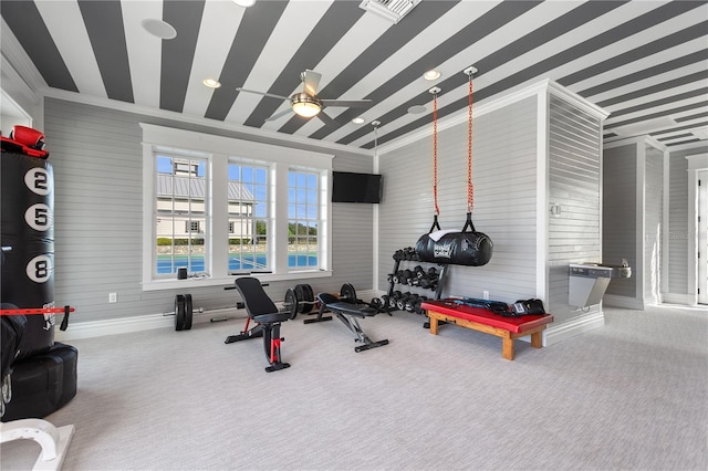 workout room featuring ceiling fan, crown molding, and carpet flooring