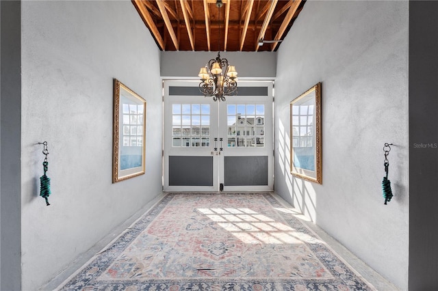 unfurnished sunroom featuring an inviting chandelier and french doors