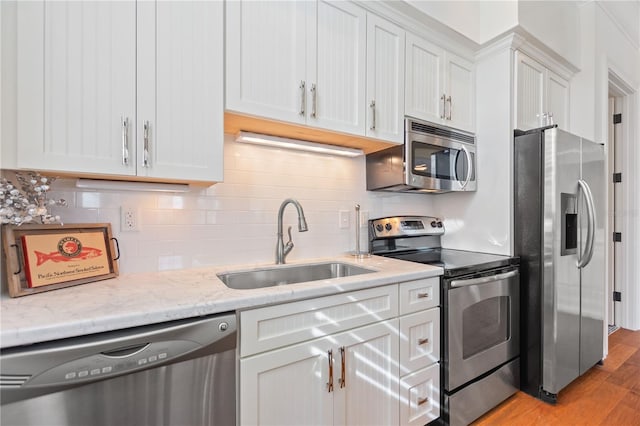 kitchen featuring appliances with stainless steel finishes, white cabinets, and sink