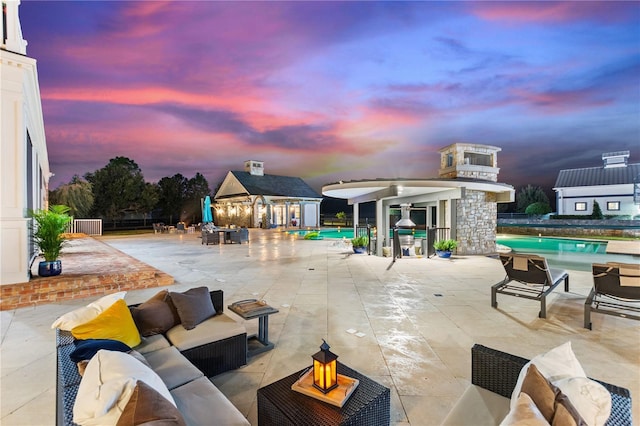 patio terrace at dusk featuring an outdoor hangout area and an outdoor structure