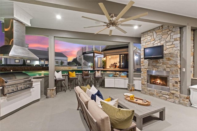 view of patio / terrace with grilling area, ceiling fan, and an outdoor living space with a fireplace