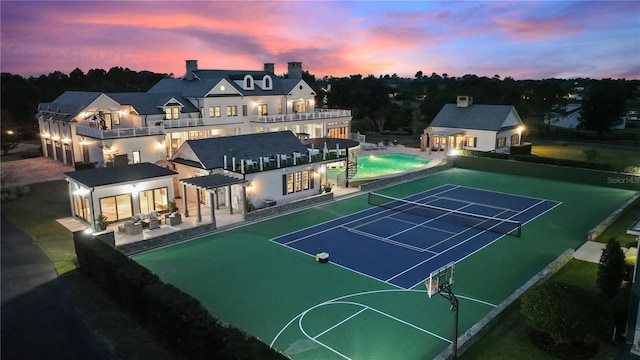 view of tennis court featuring basketball court and a patio