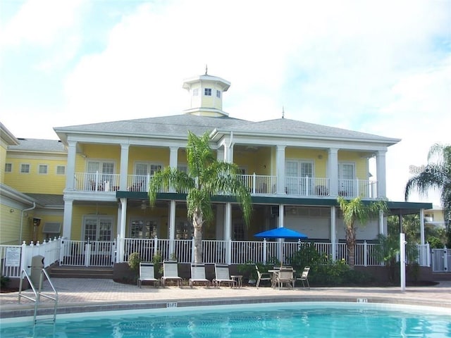 back of house featuring a balcony and a community pool