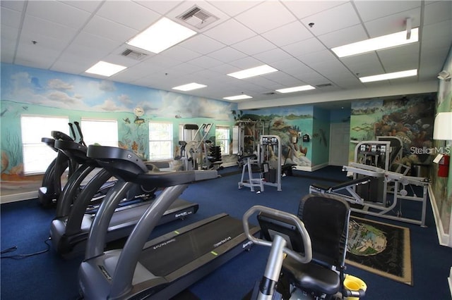 gym with carpet floors and a paneled ceiling