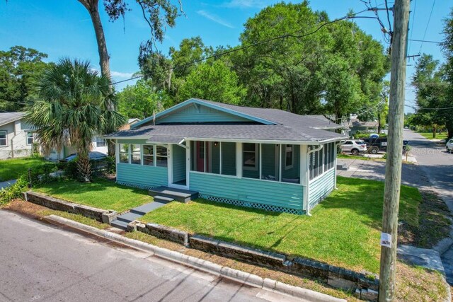 view of front of house featuring a front lawn and a sunroom