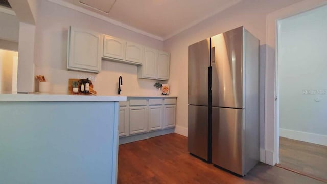 kitchen featuring stainless steel fridge, dark hardwood / wood-style floors, and white cabinetry