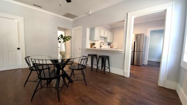 dining space with sink, ceiling fan, and dark hardwood / wood-style flooring