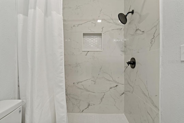 bathroom featuring a shower with shower curtain and toilet