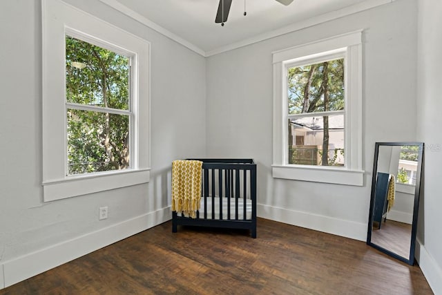 bedroom featuring ceiling fan, ornamental molding, multiple windows, and dark hardwood / wood-style flooring