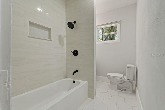 bathroom with toilet, tile floors, and tiled shower / bath combo