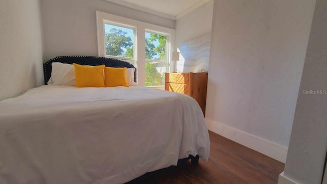 bedroom with dark hardwood / wood-style flooring