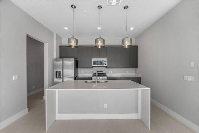 kitchen featuring stainless steel appliances, pendant lighting, and a center island with sink