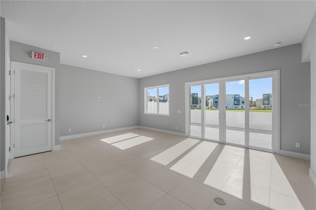 unfurnished room featuring french doors and light tile patterned floors