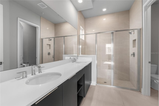 bathroom featuring vanity, a shower with shower door, toilet, and tile patterned flooring