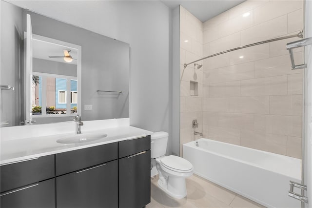 full bathroom with ceiling fan, vanity, tiled shower / bath combo, tile patterned floors, and toilet