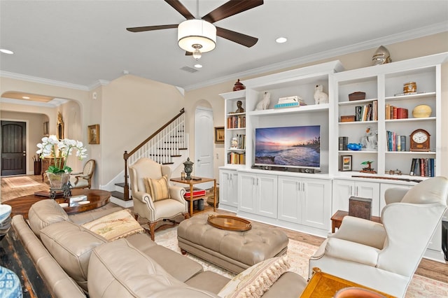 14372 Sunbridge Cir, Winter Garden, FL 34787 - living room featuring arched walkways, stairs, ornamental molding, light wood-style flooring, and ceiling fan