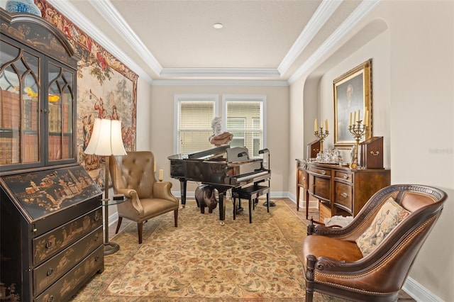 sitting room with a tray ceiling and crown molding