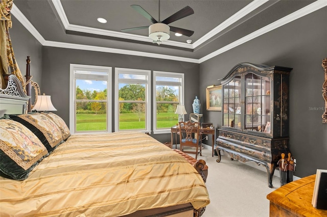 carpeted bedroom featuring a tray ceiling, ceiling fan, and ornamental molding