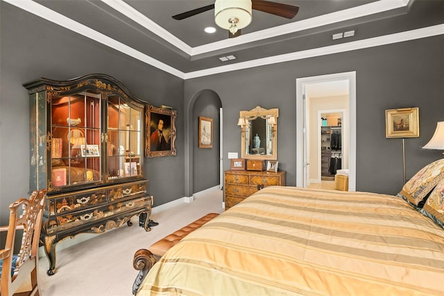 bedroom with carpet floors, a tray ceiling, ceiling fan, and ornamental molding