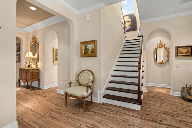 14372 Sunbridge Cir, Winter Garden, FL 34787 - staircase featuring wood finished floors, arched walkways, ornamental molding, and recessed lighting