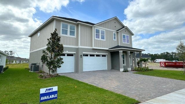 view of front facade with central AC, a garage, and a front lawn