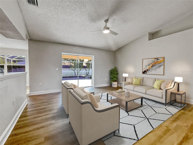 living room featuring a textured ceiling, light hardwood / wood-style flooring, ceiling fan, and lofted ceiling