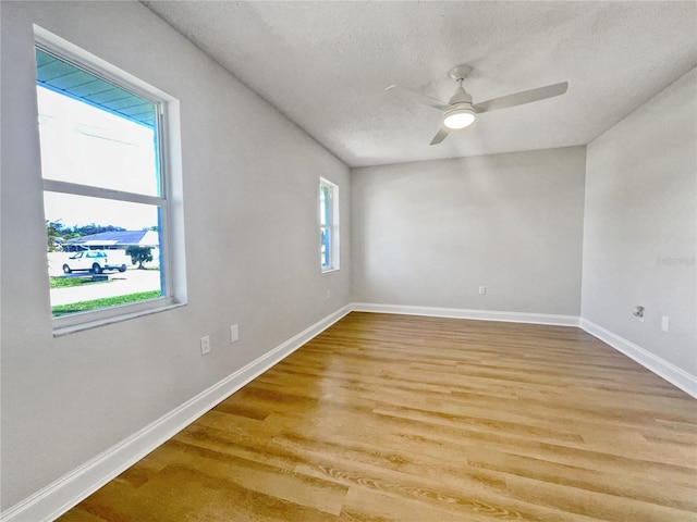 empty room featuring a textured ceiling, light hardwood / wood-style floors, and ceiling fan