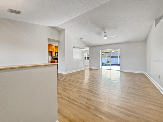 unfurnished living room featuring a textured ceiling, light hardwood / wood-style floors, ceiling fan, and lofted ceiling